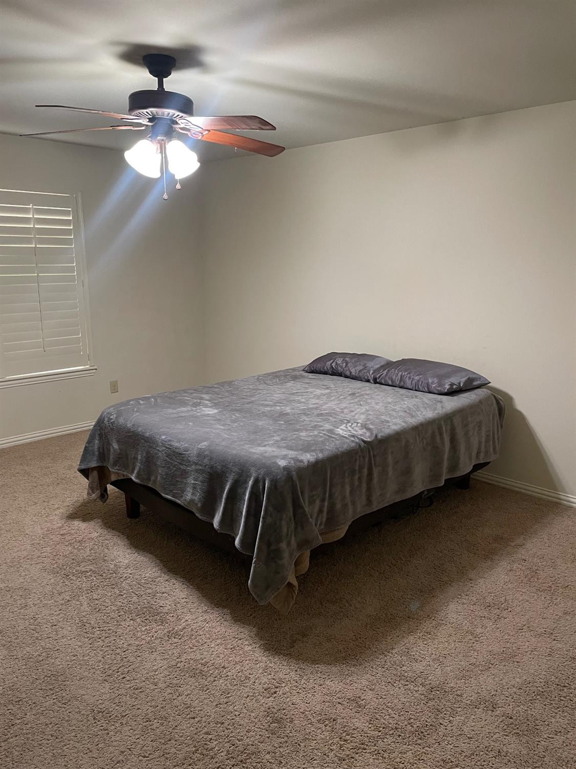 2624 112th Street Lubbock, TX 79423 - Photo 11 of 12 a bed sitting in a room next to a window