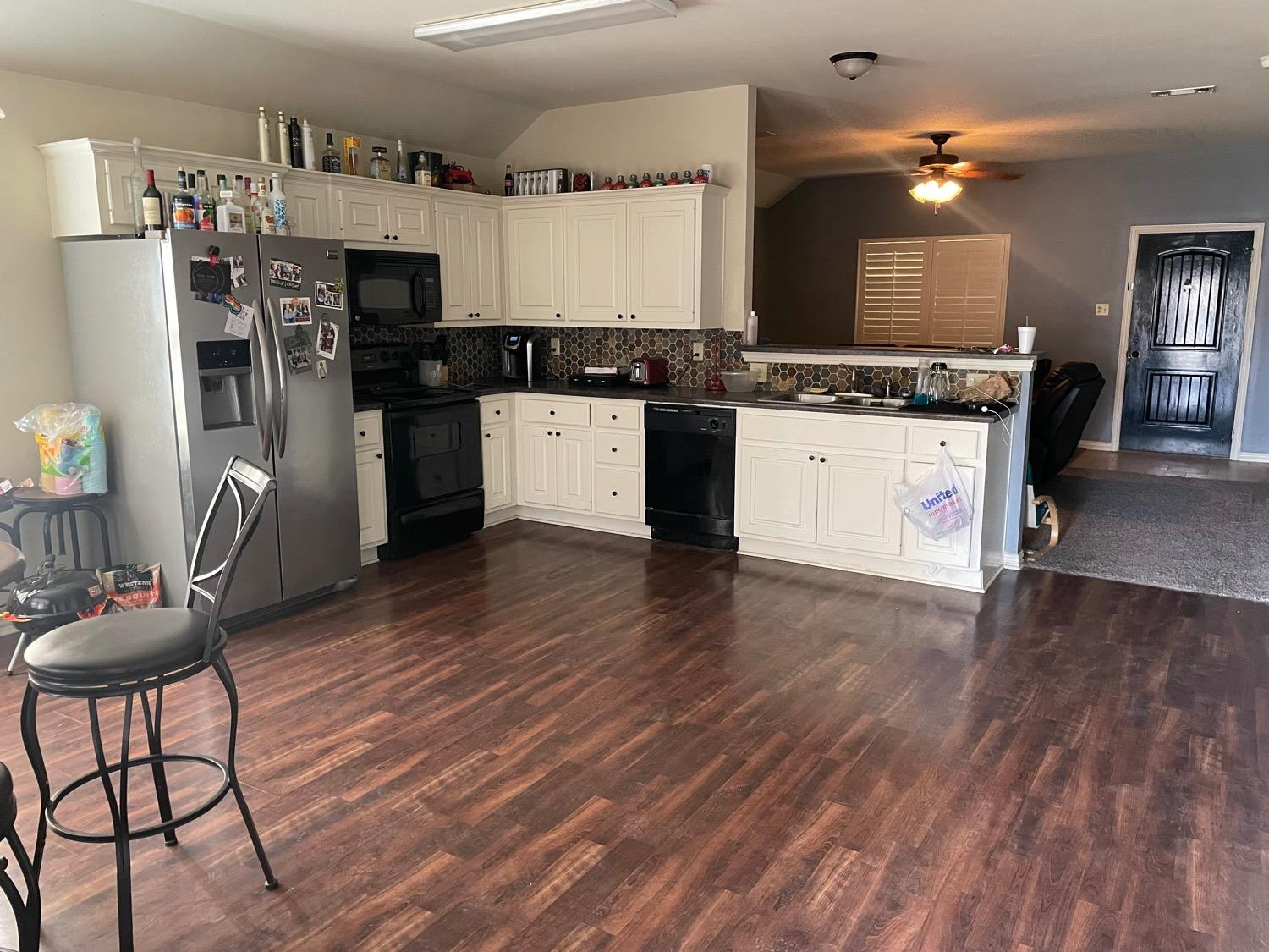2624 112th Street Lubbock, TX 79423 - Photo 6 of 12 a kitchen with stainless steel appliances kitchen island granite countertop a refrigerator a stove and a wooden floors