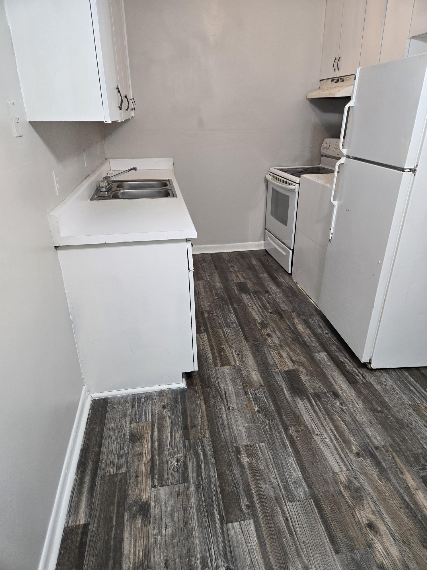 a utility room with wooden floor washer and dryer