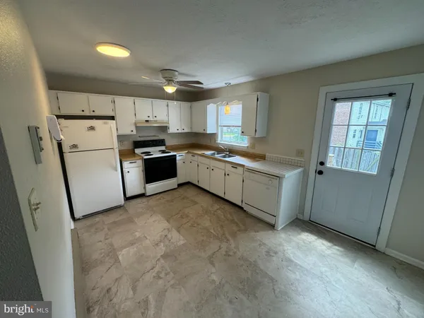 a kitchen with a sink a stove top oven and cabinetry