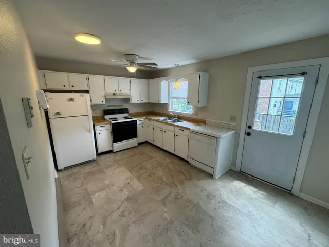 a kitchen with a sink a stove top oven and cabinetry