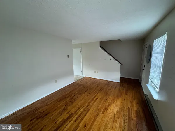 a view of empty room with wooden floor