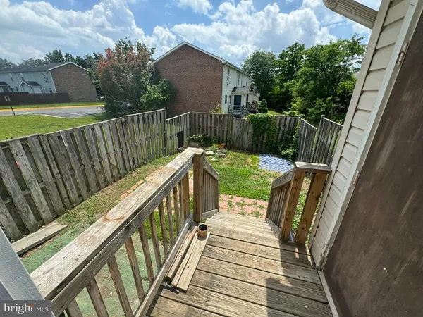 a balcony with wooden floor stairs and wooden fence