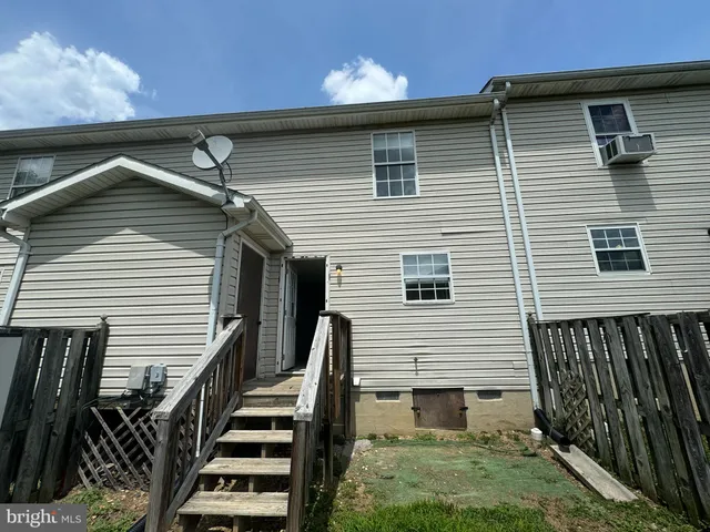 a front view of a house with stairs and a yard