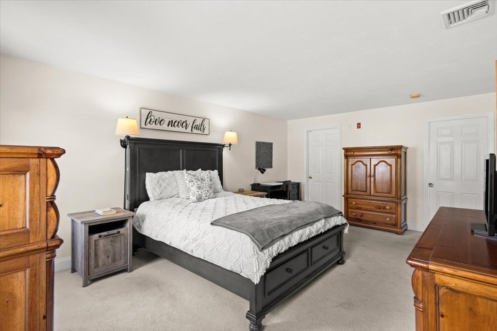 125 Independence Avenue Hanson, MA 02341 - Photo 17 of 42 a spacious bedroom with a bed and dresser with wooden floor