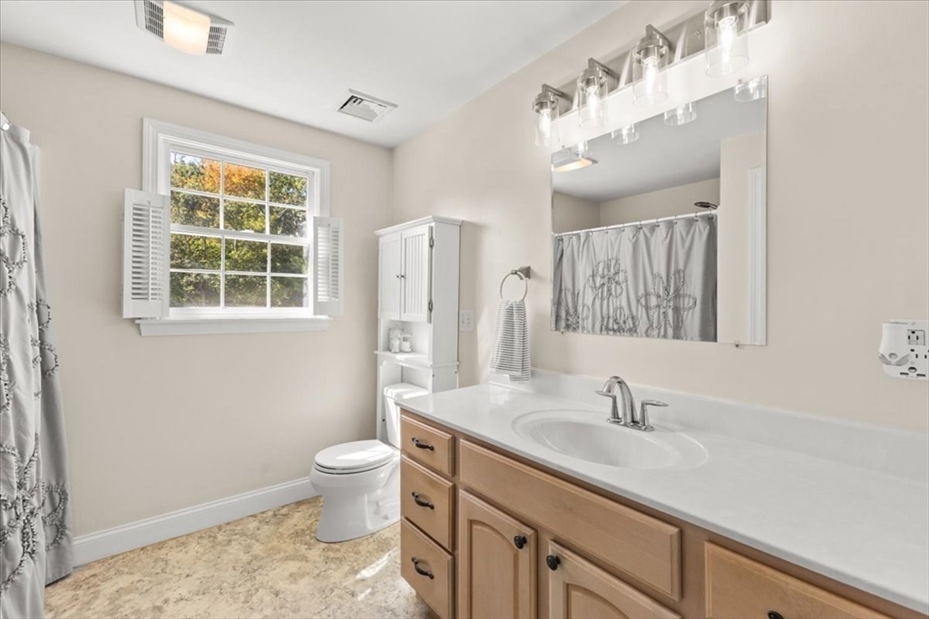 125 Independence Avenue Hanson, MA 02341 - Photo 18 of 42 a bathroom with a sink a toilet and a large mirror