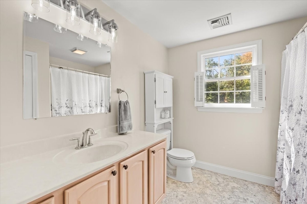 125 Independence Avenue Hanson, MA 02341 - Photo 21 of 42 a bathroom with a granite countertop sink toilet a large mirror a shower and a window