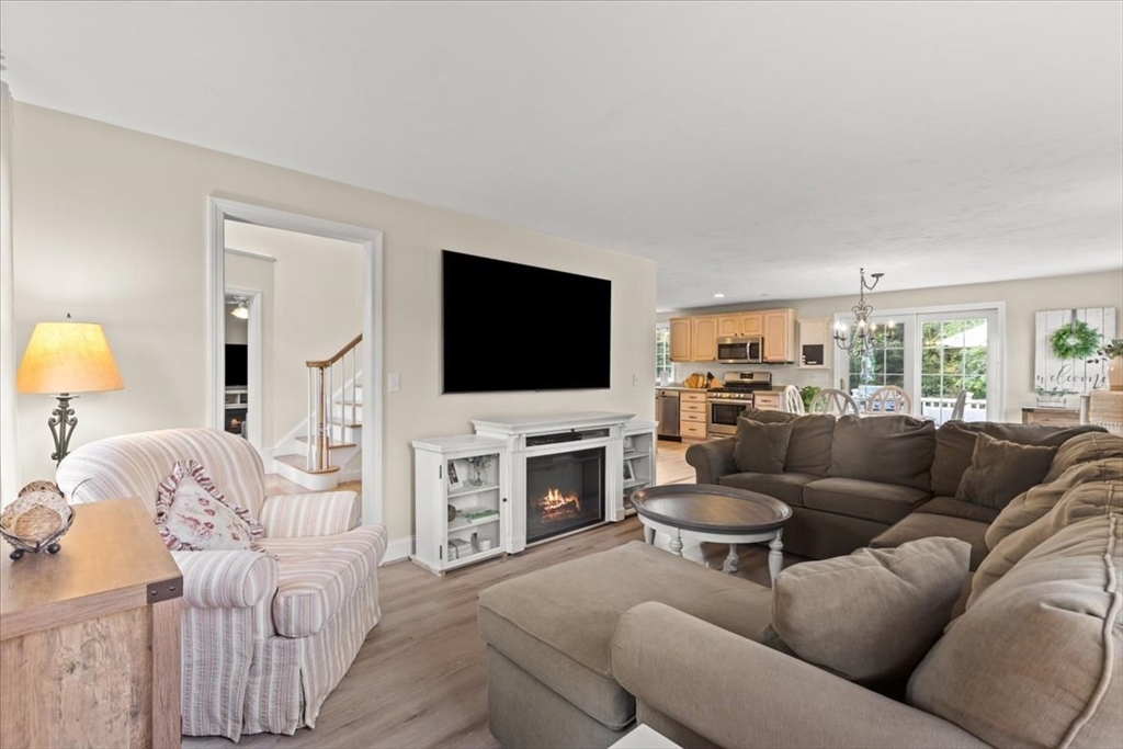 125 Independence Avenue Hanson, MA 02341 - Photo 9 of 42 a living room with furniture a flat screen tv and a fireplace