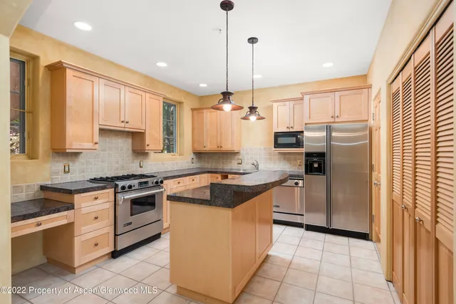 a kitchen with stainless steel appliances granite countertop a stove and a refrigerator