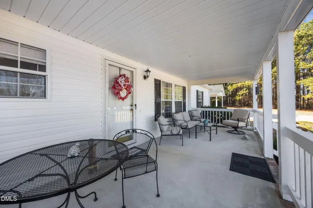 a living room with furniture a flat screen tv and a window
