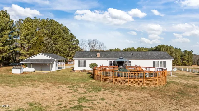an aerial view of a house with swimming pool and trees