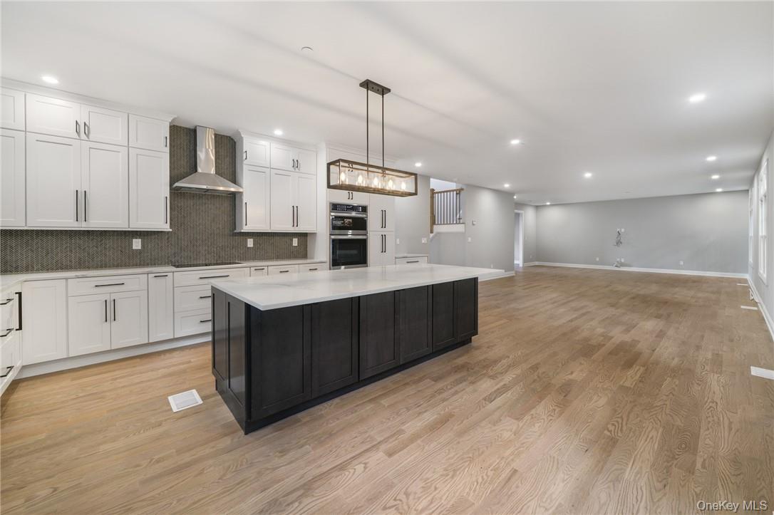 14 Shady Road Ardsley, NY 10502 - Photo 17 of 37 a kitchen with kitchen island granite countertop a sink cabinets and wooden floor