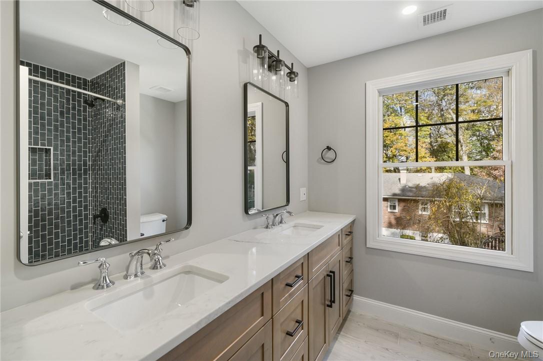 14 Shady Road Ardsley, NY 10502 - Photo 28 of 37 a bathroom with a granite countertop double vanity sink a mirror and a window