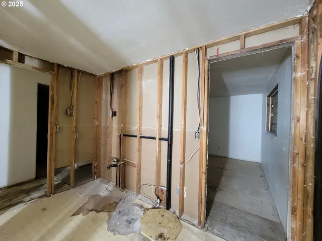 a view of a livingroom with wooden floor and a hallway