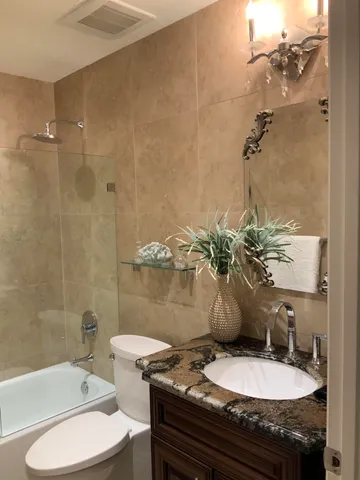 a bathroom with a granite countertop toilet a sink and bathtub