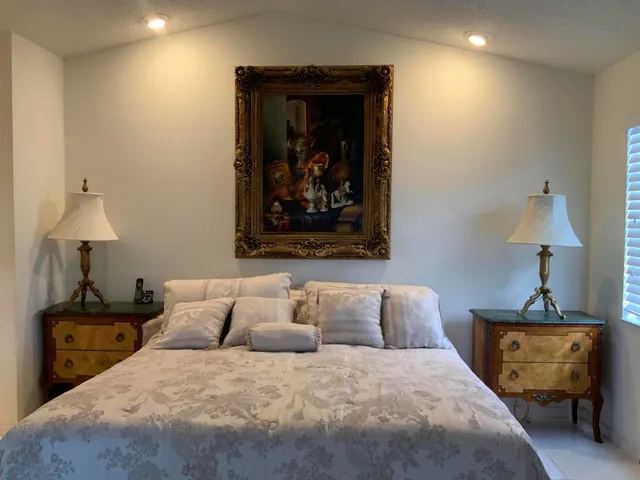 a bedroom with a bed and a lamp with the dresser