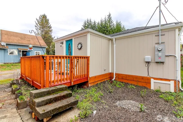 a view of a house with wooden fence next to a yard
