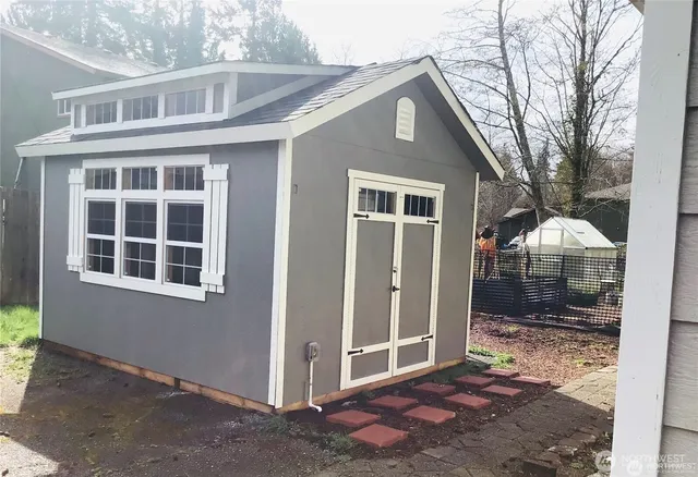 a view of a backyard with plants and large tree