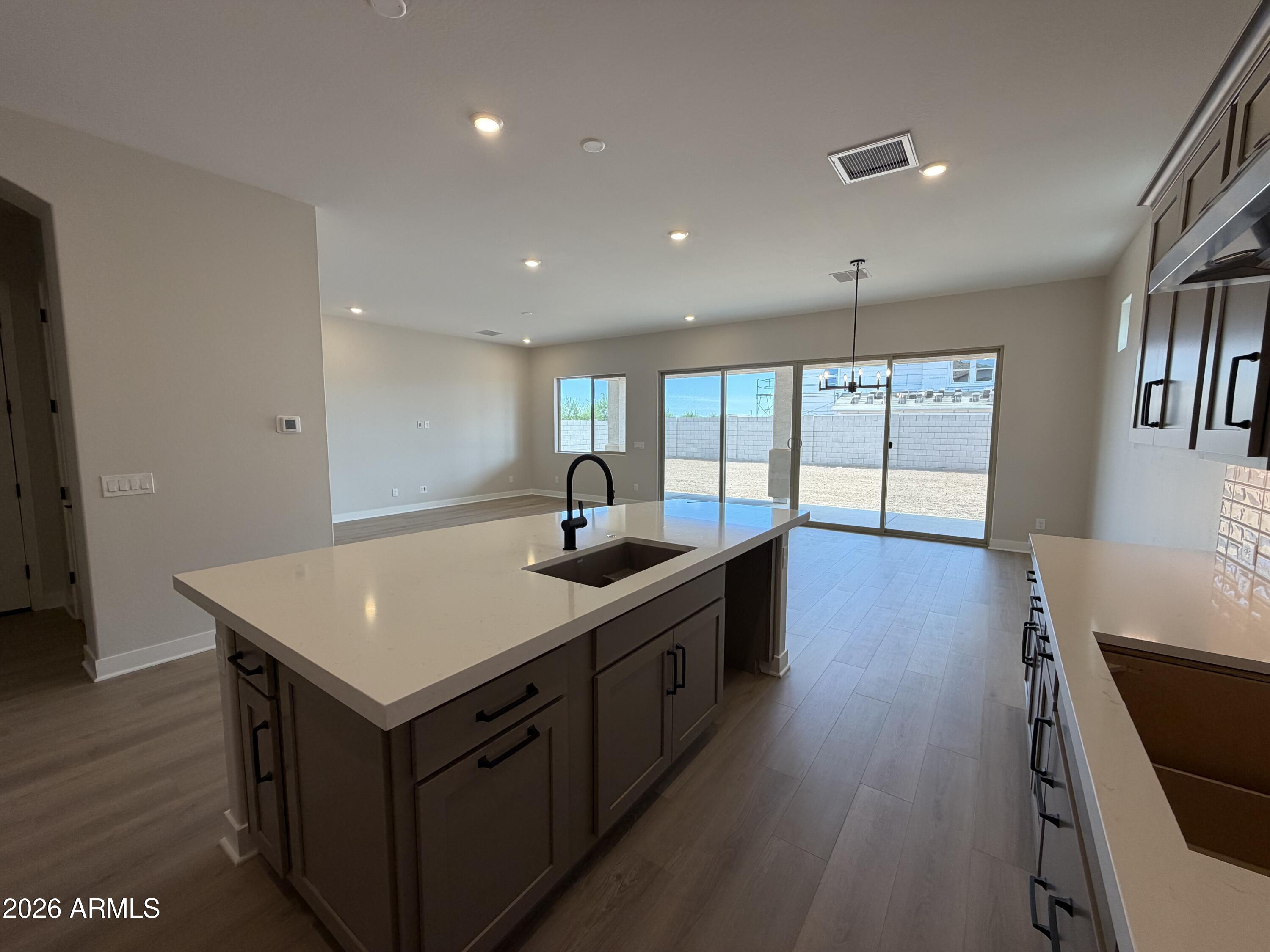 15767 West Sand Hills Road Surprise, AZ 85387 - Photo 5 of 60 a kitchen with a stove a sink a window and a dining table