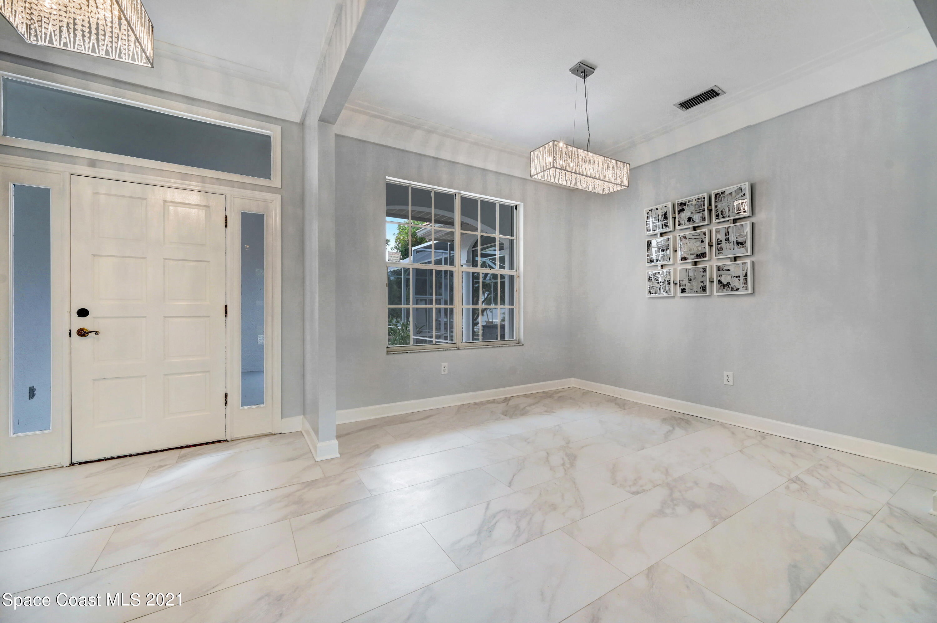 4601 Indian River Drive Cocoa, FL 32927 - Photo 12 of 51 an empty room with windows and chandelier