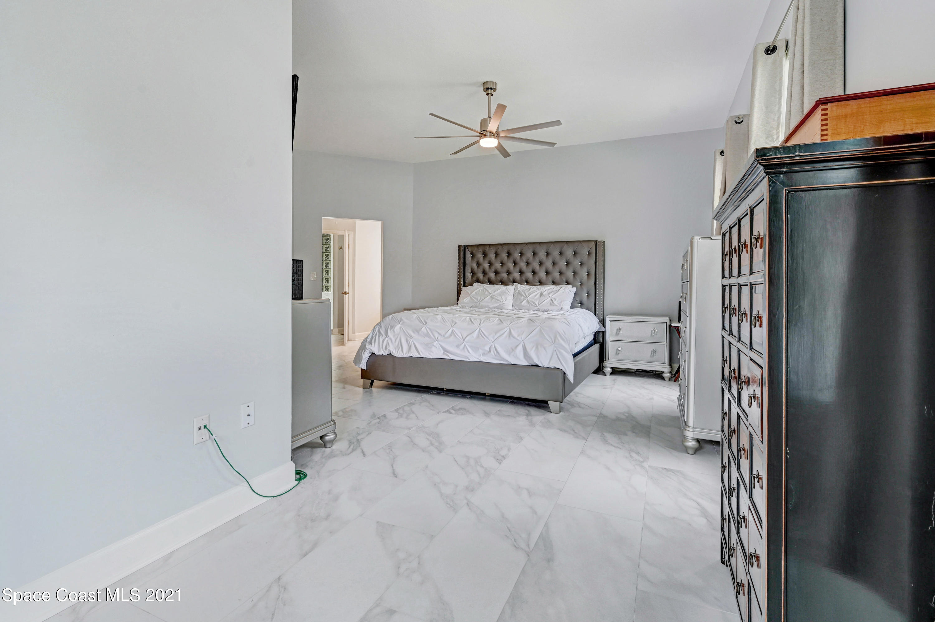 4601 Indian River Drive Cocoa, FL 32927 - Photo 27 of 51 a spacious bedroom with a bed and a chandelier