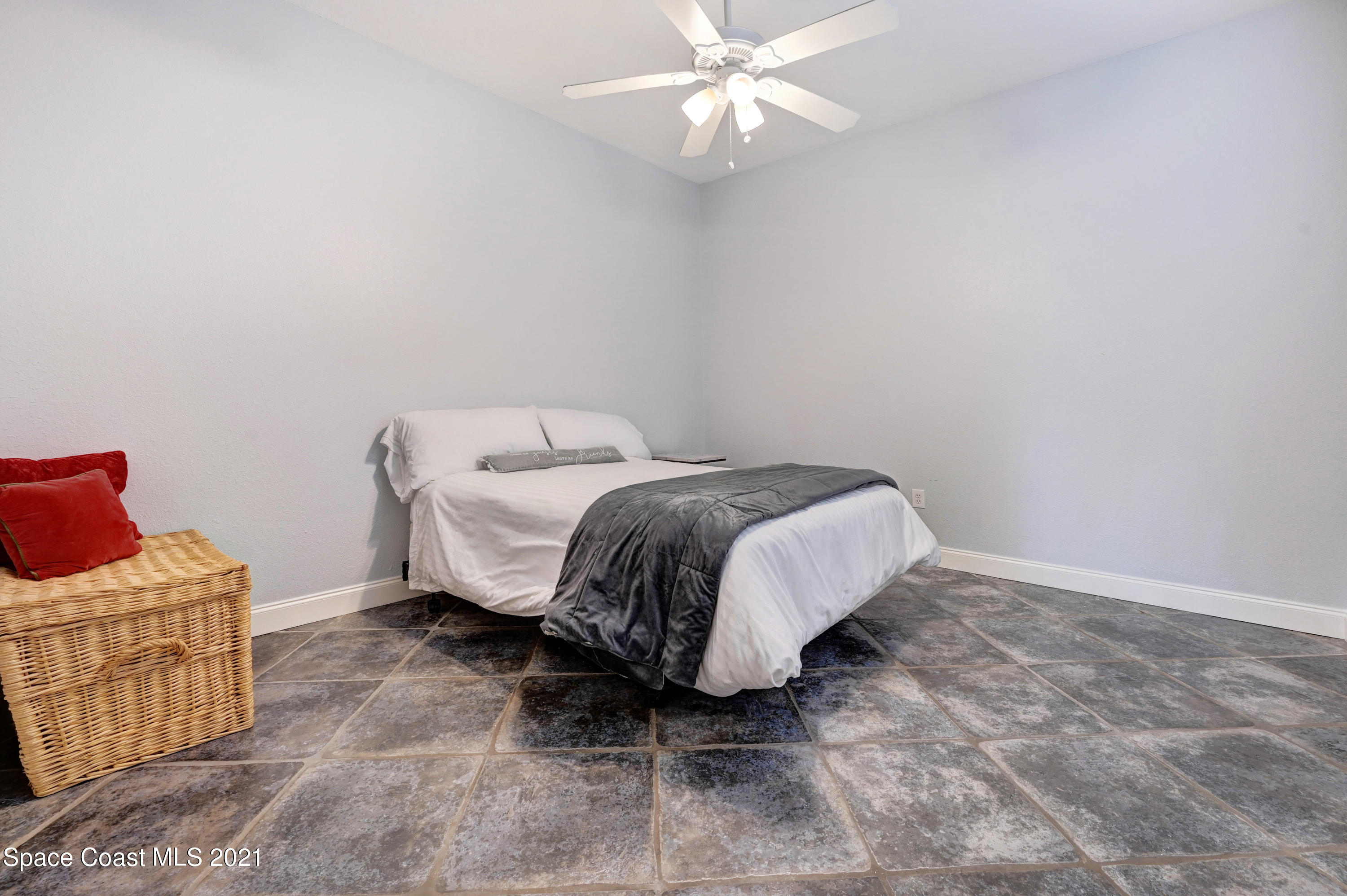 4601 Indian River Drive Cocoa, FL 32927 - Photo 32 of 51 a bed sitting in a bedroom next to a window and a chandelier