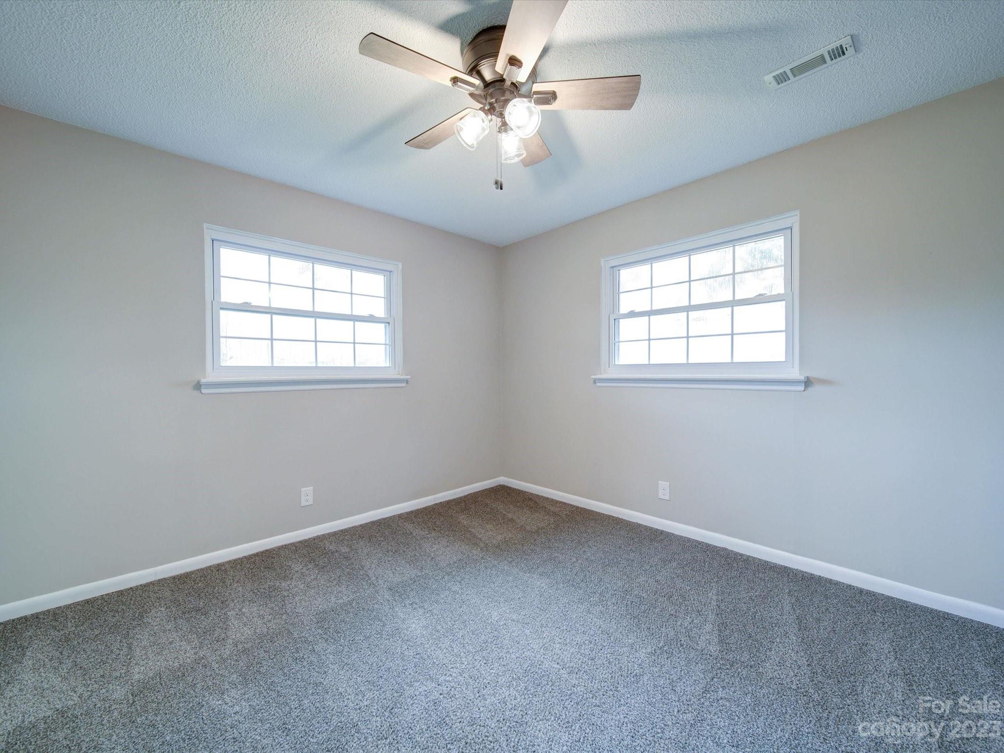 893 State Rd S-13-35 Pageland, SC 29728 - Photo 23 of 25 an empty room with windows and ceiling fan