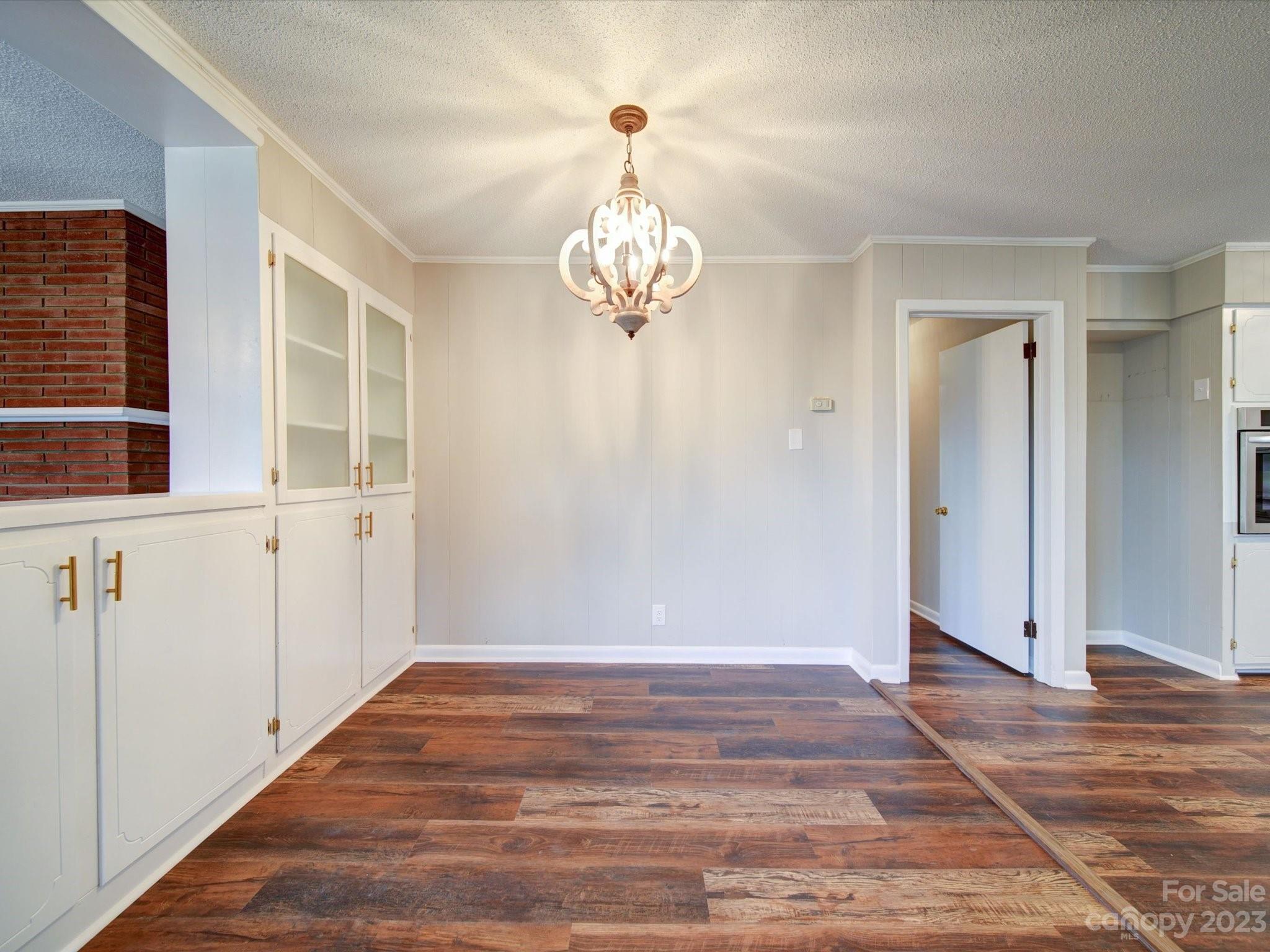 893 State Rd S-13-35 Pageland, SC 29728 - Photo 7 of 25 a view of a chandelier in big room with wooden floor and chandelier