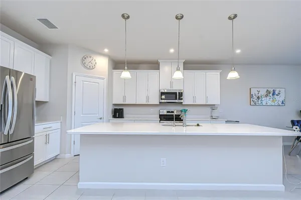a large white kitchen with lots of counter space and appliances