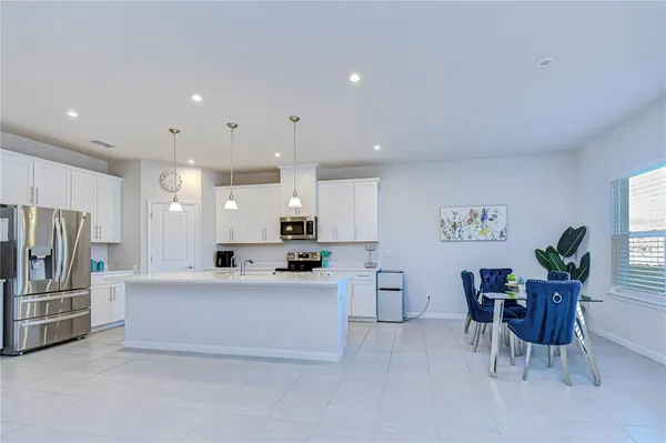a large white kitchen with a lot of counter space and a sink