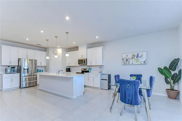 a large kitchen with kitchen island a large counter space a sink appliances and cabinets