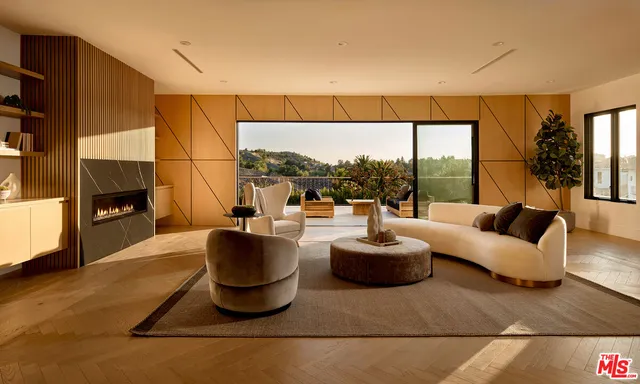 a living room with fireplace furniture and a floor to ceiling window