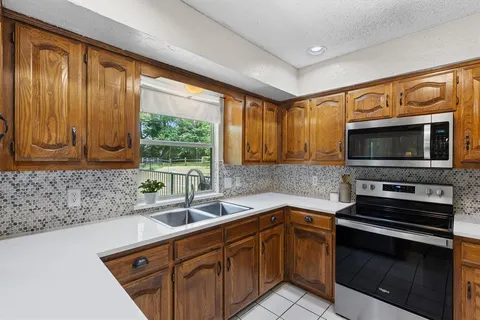 a kitchen with stainless steel appliances a stove sink and microwave