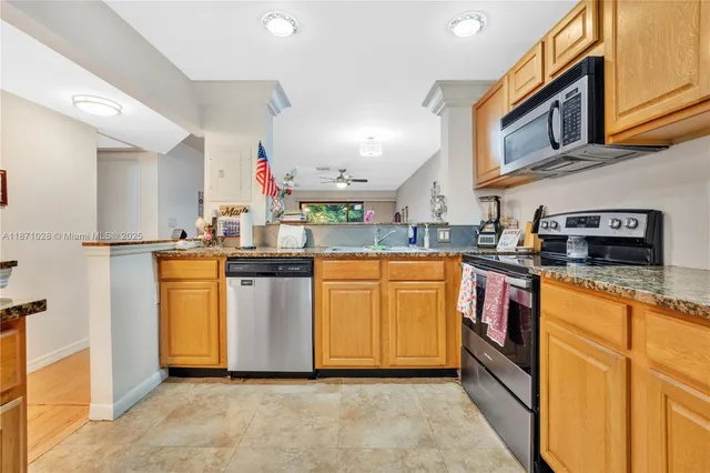 a kitchen with stainless steel appliances granite countertop a sink a stove and a refrigerator