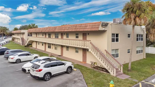 a white building that has a tree in front of it