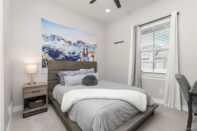 a bed sitting in a bedroom next to a window with a baby bed next to a window