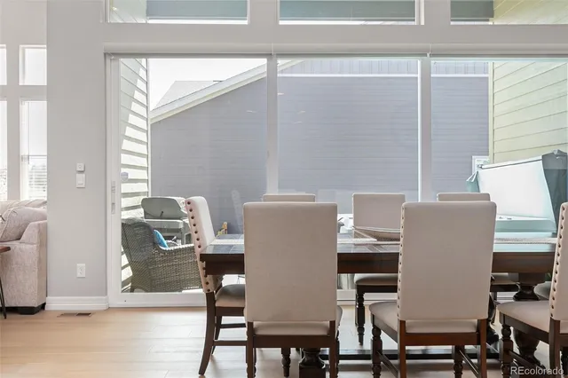 a kitchen with stainless steel appliances kitchen island granite countertop a refrigerator a stove a sink dishwasher and white cabinets with wooden floor