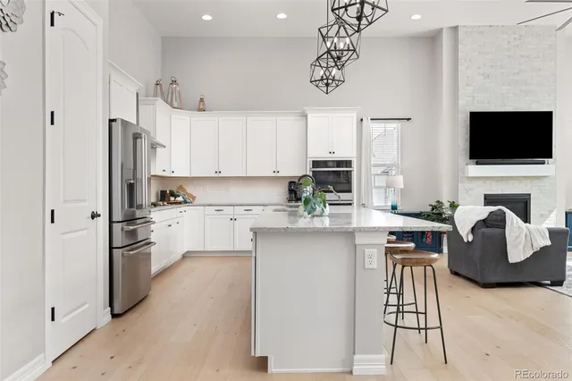 a kitchen with stainless steel appliances a table chairs refrigerator and microwave