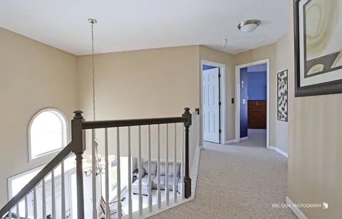 a view of a hallway with entryway and wooden floor