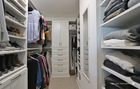 a view of walk in closet with clothes and shoes