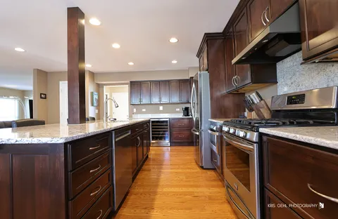 a kitchen with stainless steel appliances granite countertop a sink a stove and a refrigerator