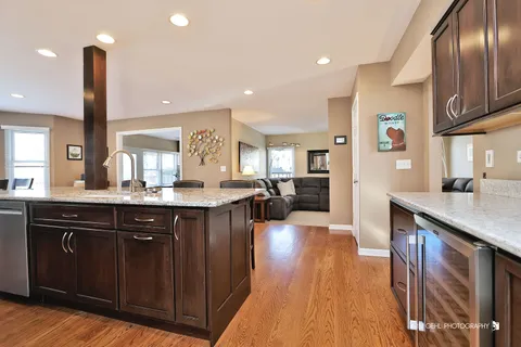 a kitchen with stainless steel appliances granite countertop a sink a stove and a wooden floors