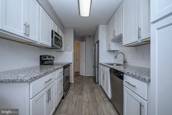 a kitchen with stainless steel appliances granite countertop a sink stove and cabinets