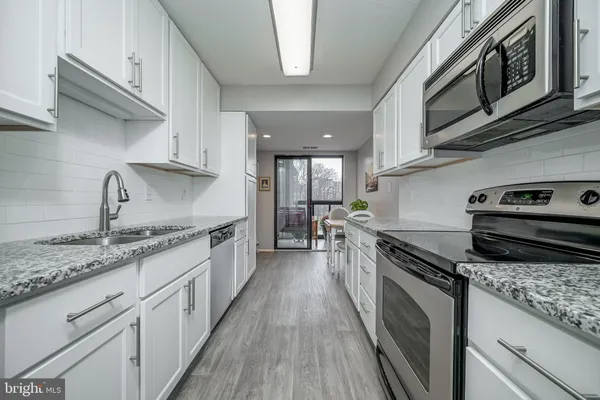 a kitchen with granite countertop stainless steel appliances and wooden cabinets