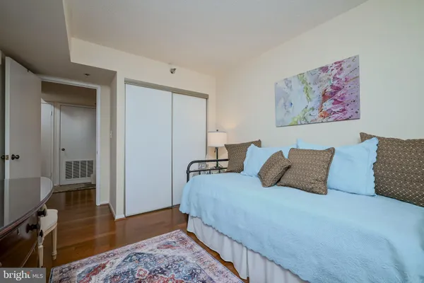 a bedroom with bed and wooden floor