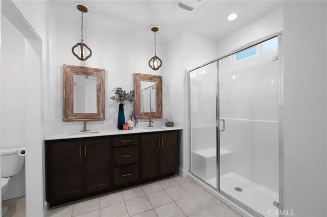 a bathroom with a double vanity sink mirror and shower