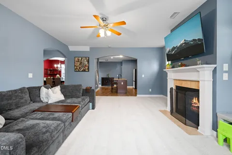 a living room with furniture a flat screen tv and a fireplace