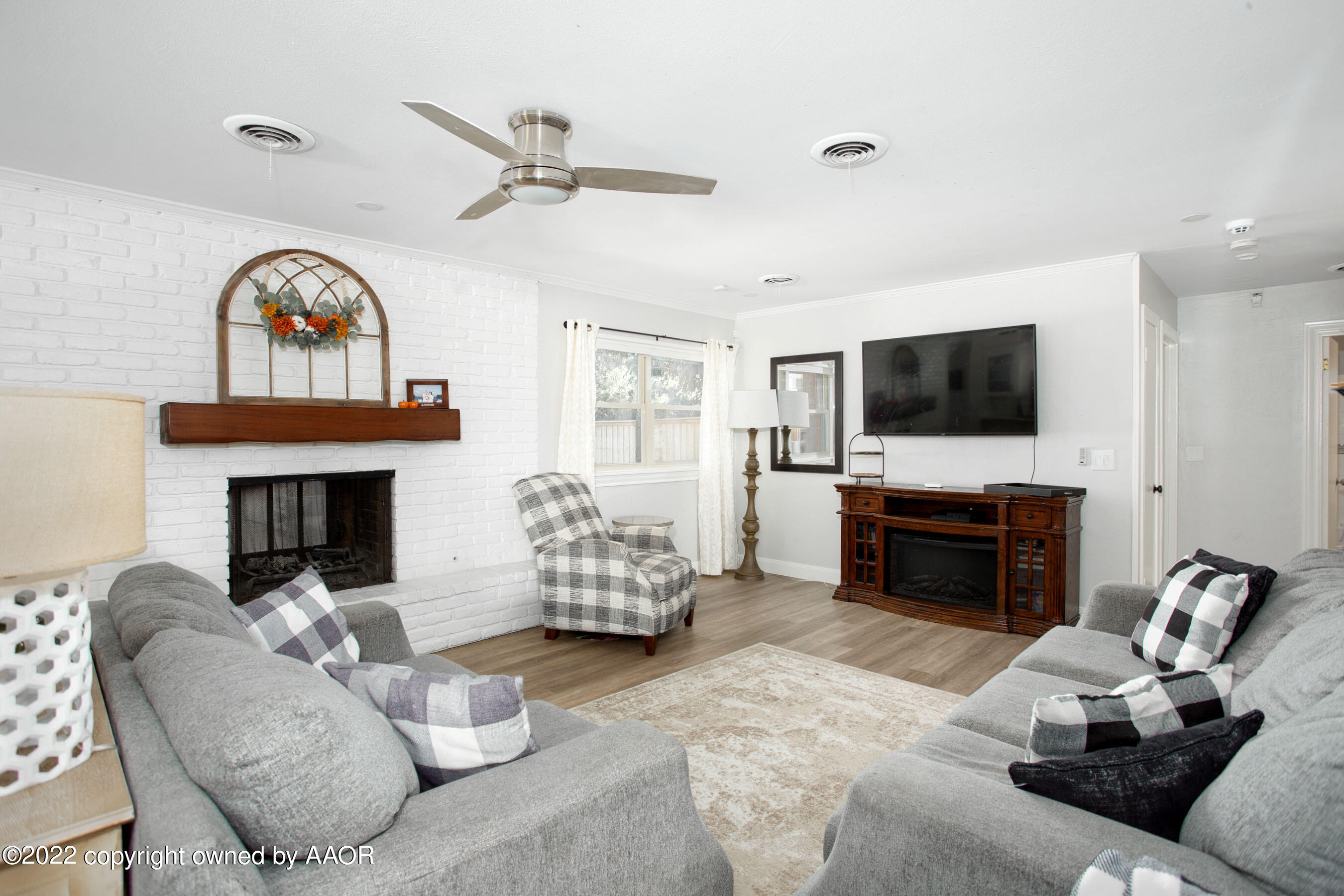 7214 Jameson Road Amarillo, TX 79106 - Photo 14 of 31 a living room with furniture a fireplace and a flat screen tv