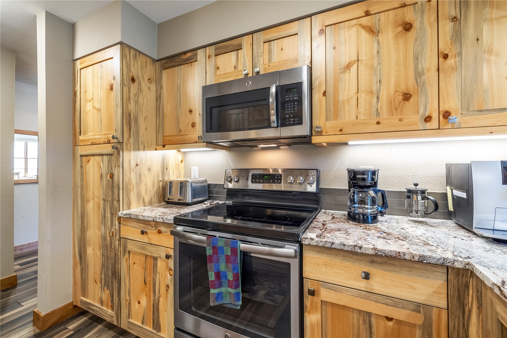 180 Tennis Club Road, Unit 1636 Keystone, CO 80435 - Photo 10 of 28 Kitchen with appliances with stainless steel finishes, dark hardwood / wood-style flooring, and light stone countertops