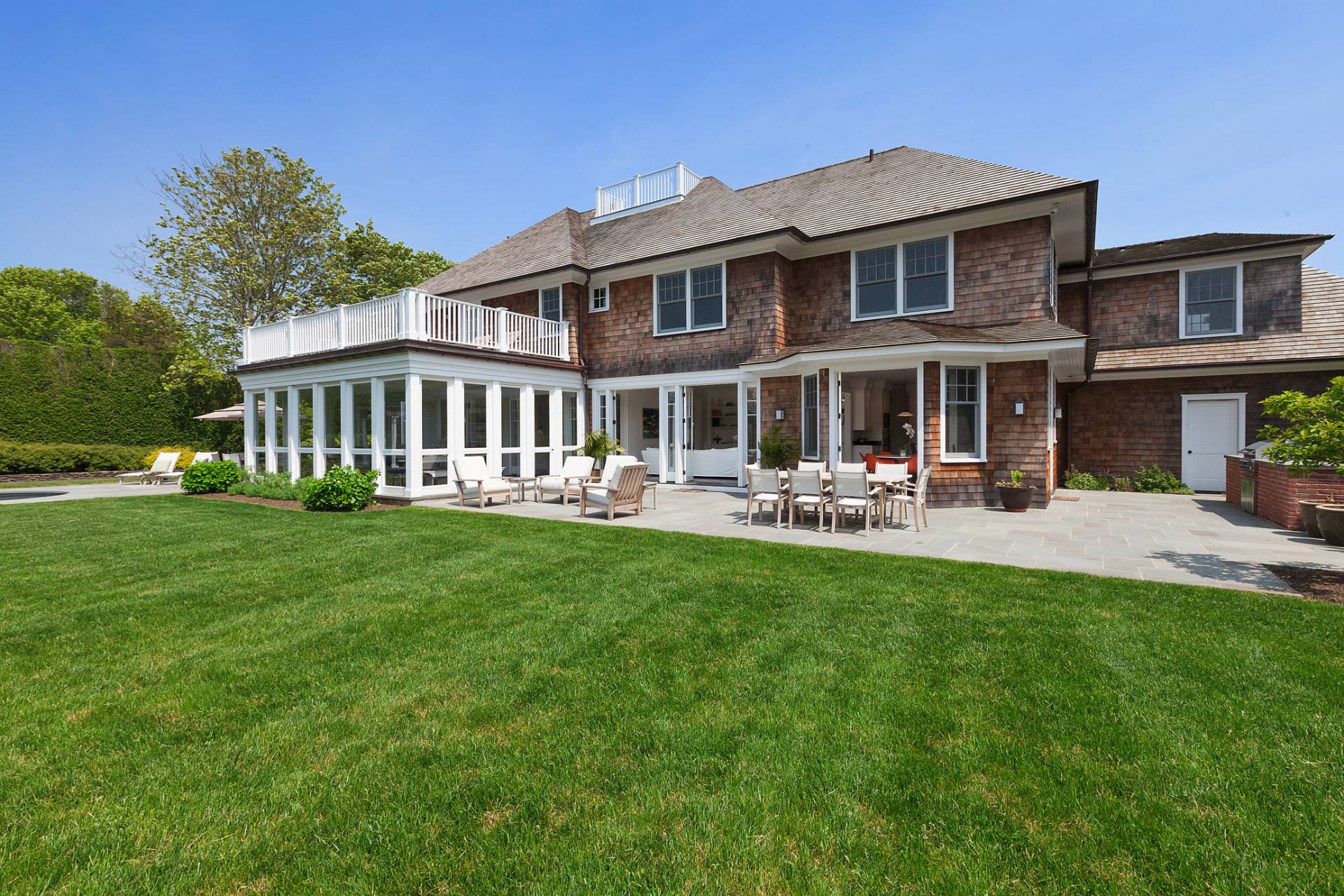 Undisclosed Address Water Mill, NY 11976 - Photo 23 of 26 a front view of a house with a yard table and chairs